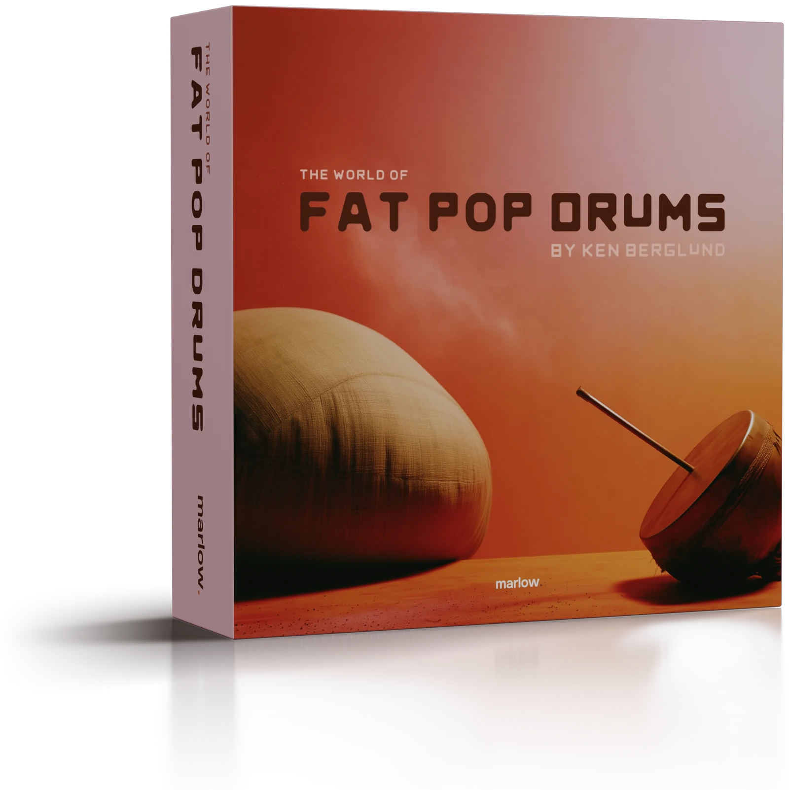 The World of Fat Pop Drums as a box: on the cover, a burlap sack and a hand drum on an orange floor under a sky running from red to lilac; the title down a lilac spine.